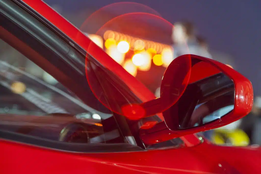 Luxury red car, closeup details with city lights behind it. Bokeh.